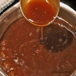 roast beef gravy being ladled out of a pan - condiments - dips- gravies -sauces