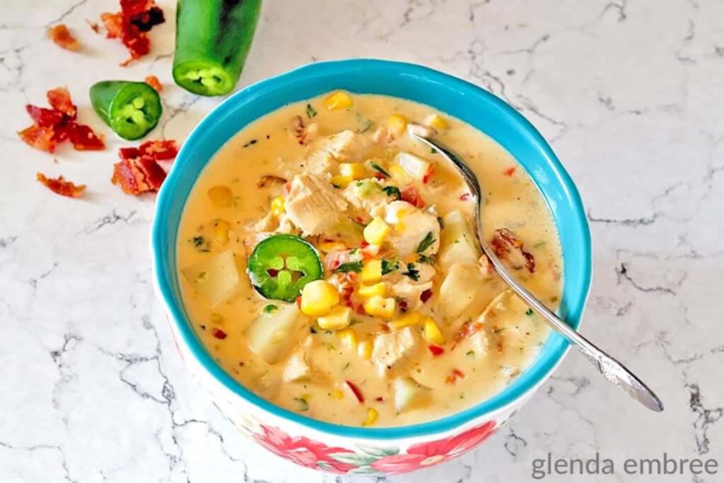 jalapeno chicken and corn chowder in a flowered ceramic bowl on a marble counter
