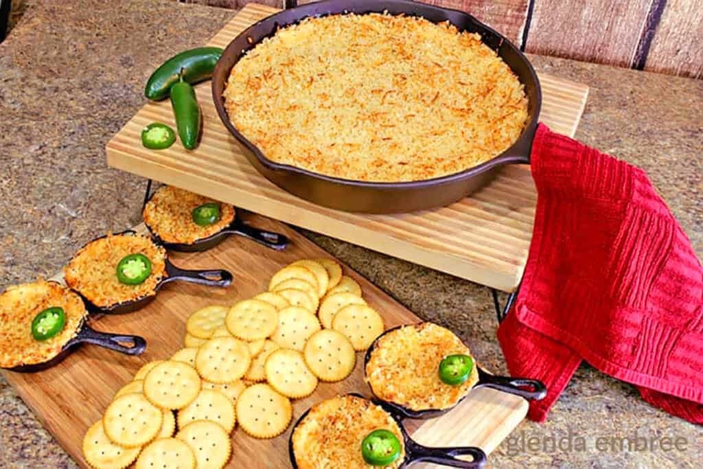 hot jalapeno popper dip in a cast iron skillet served with crackers