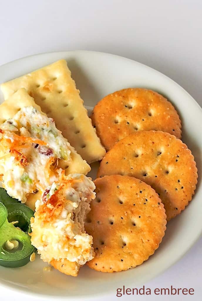 hot jalapeno popper dipspread on crackers on a white plate