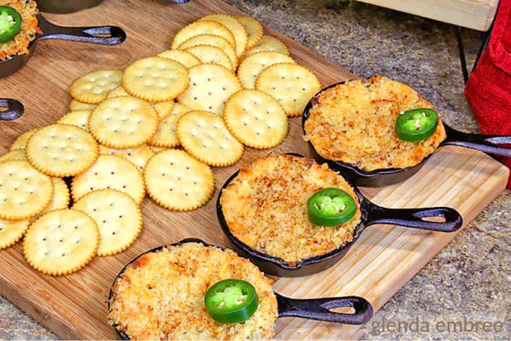 hot jalapeno popper dip in a cast iron skillet served with crackers