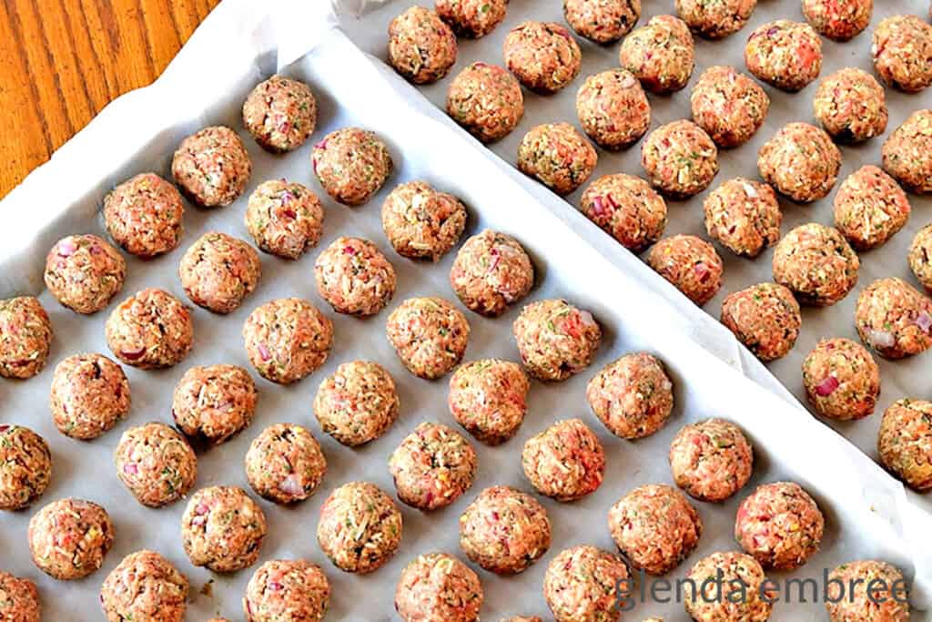 meatballs rolled and placed on parchment lined baking sheets