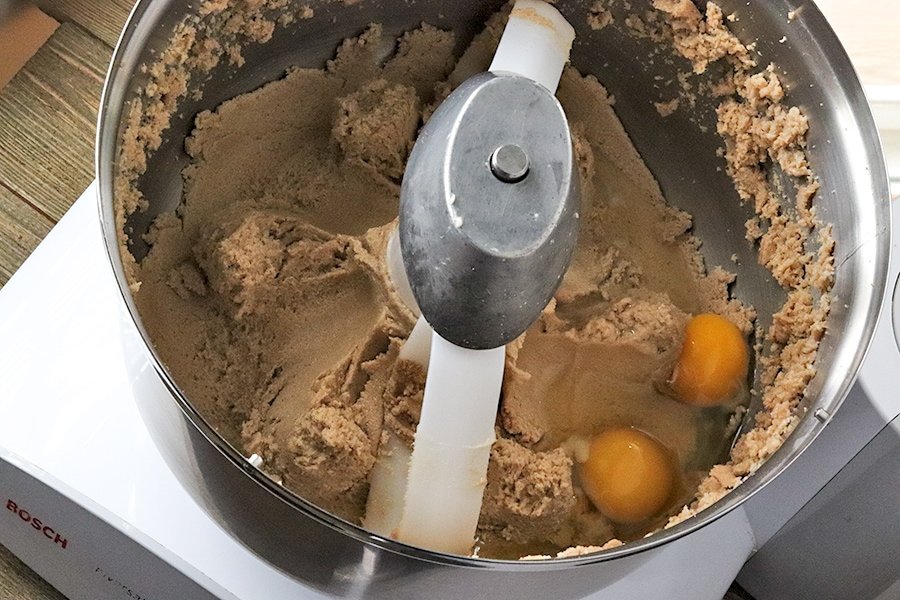 adding eggs to cookie dough mixture