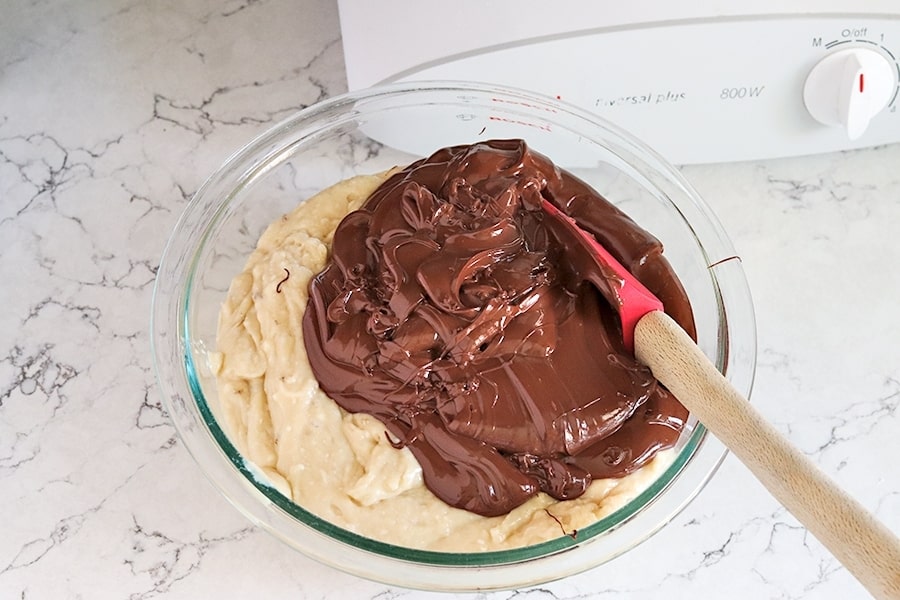 Adding melted chocolate to half the banana bread batter.