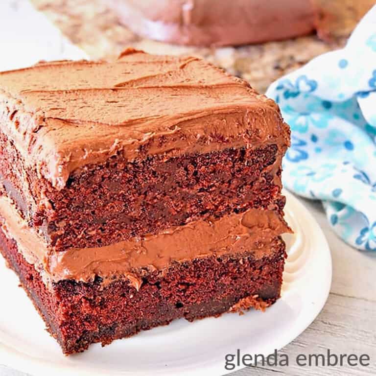Homemade Chocolate Cake slice on an ivory stoneware plate with a blue print fabric napkin alongside