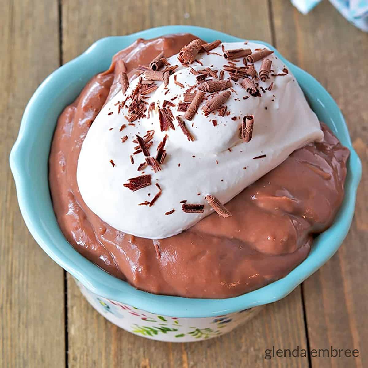 homemade chocolate pudding in a blue bowl on a wooden table
