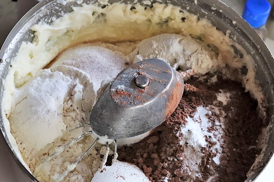 adding dry ingredients to chocolate cake batter
