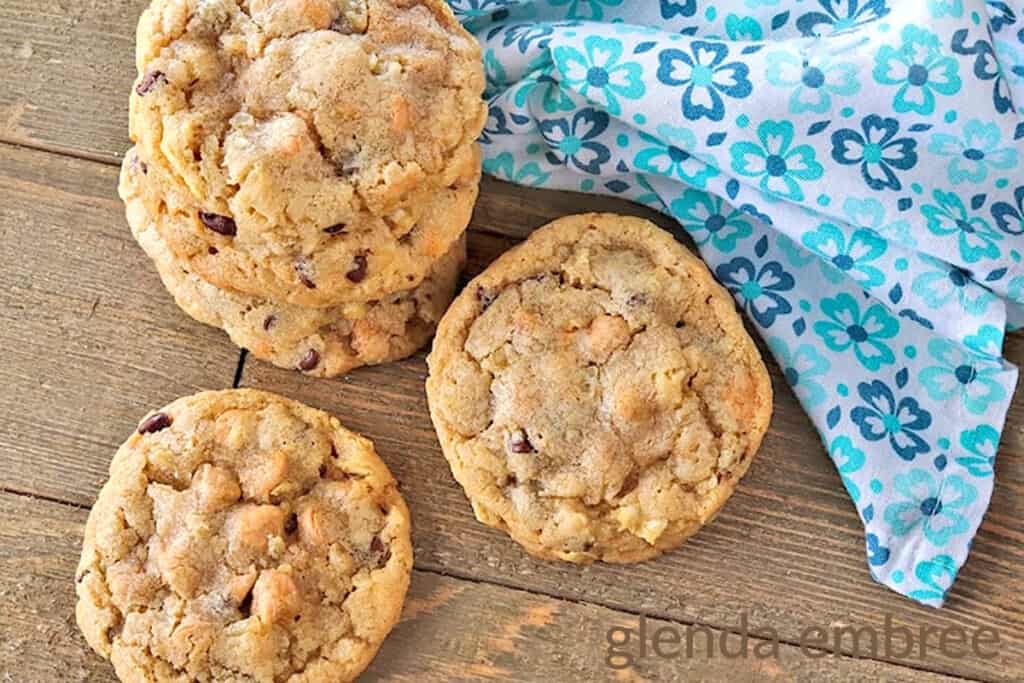 Potato Chip Cookies stacked on a rough wooden table top with a blue print fabric napkin
