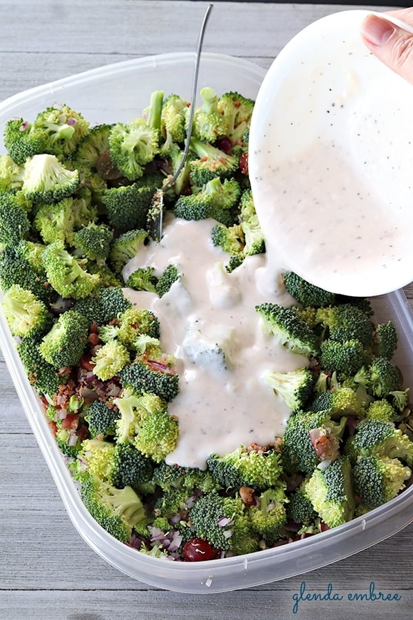 pouring dressing on broccoli salad