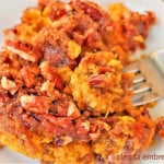 Sweet Potato Casserole on a white plate with a bite being lifted on a fork