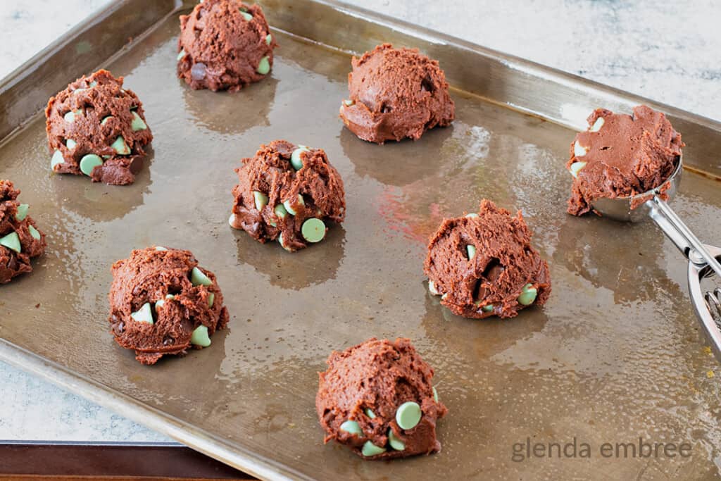cookie balls on cookie sheet next to the cookie scoop