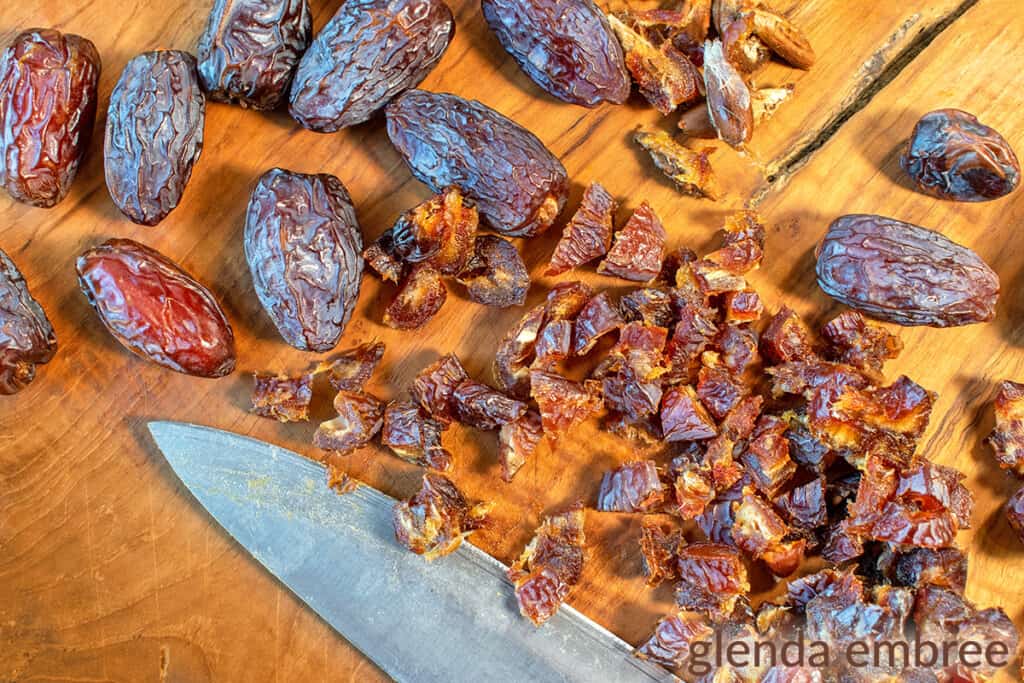 Medjool Dates being chopped on a wooden cutting board