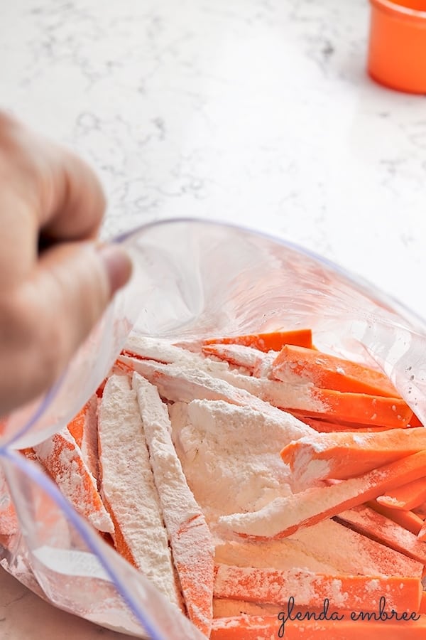 adding starch and salt to fries in bag