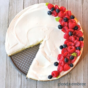 easy delicious cheesecake with raspberries and blueberries decorating the right side