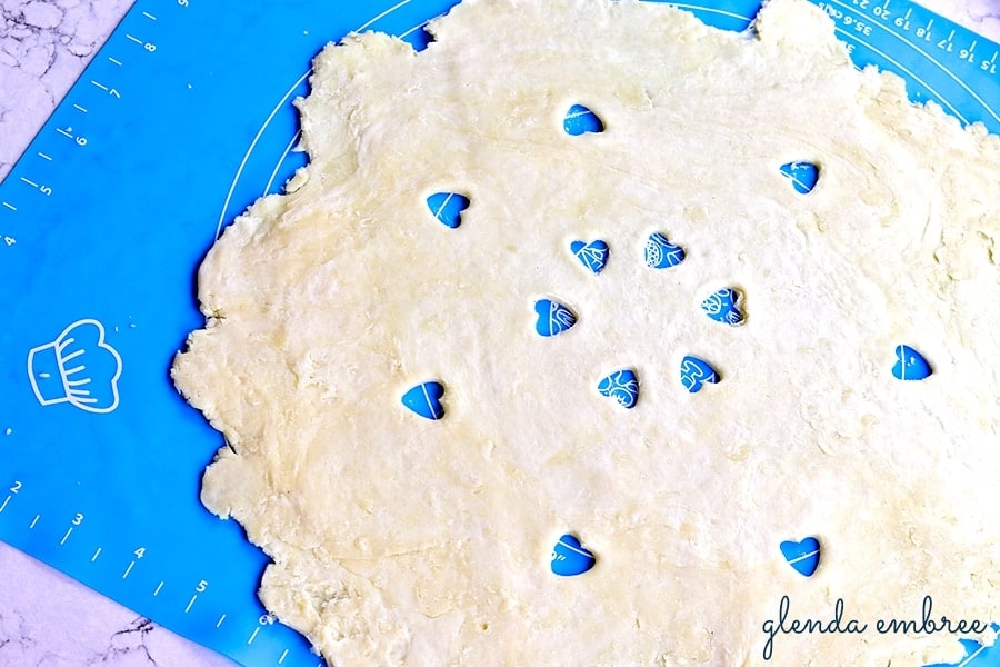 top pie crust for homemade apple pie with heart-shaped vents cut into it