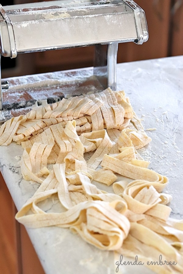 cutting homemade pasta with a pasta machine