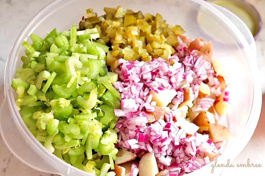 potato salad ingredients - potatoes, celery sweet pickles, onion, and the secret ingredient - sweet pickle juice