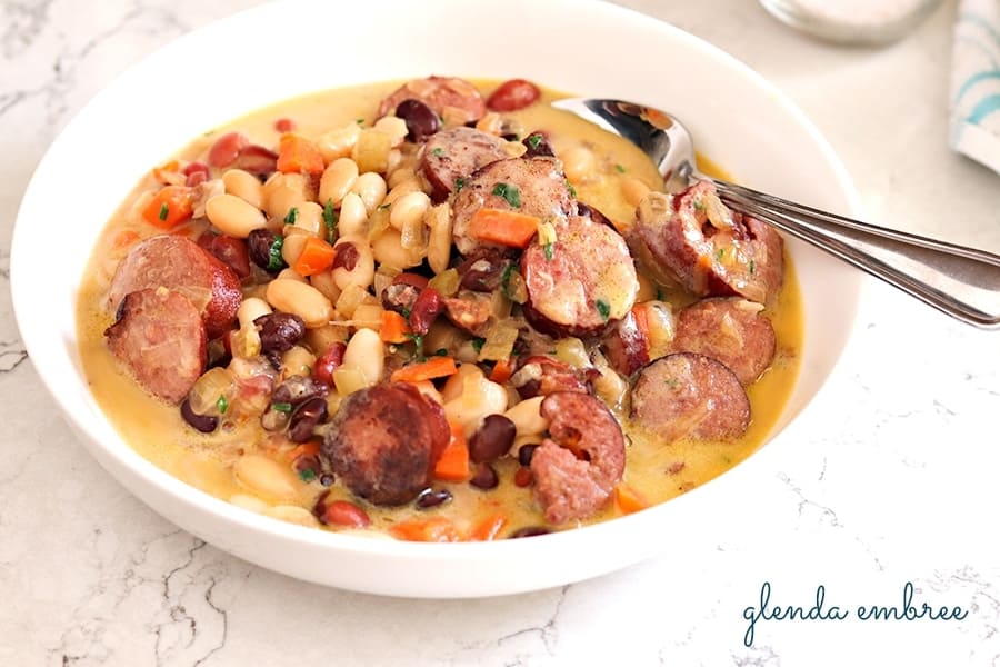 bean soup with sausage and vegetables in a bowl