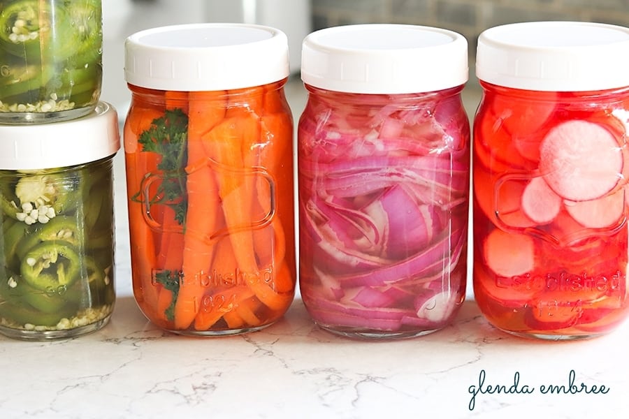 Pickled jalapenos and pickled vegetables (carrots, redonions and radishes) in jars