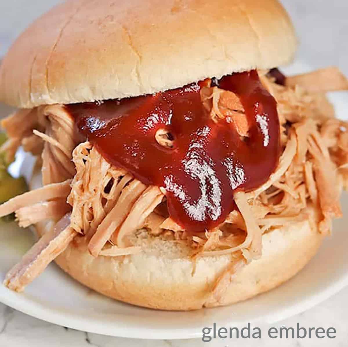 perfect pulled pork sandwich on a white plate