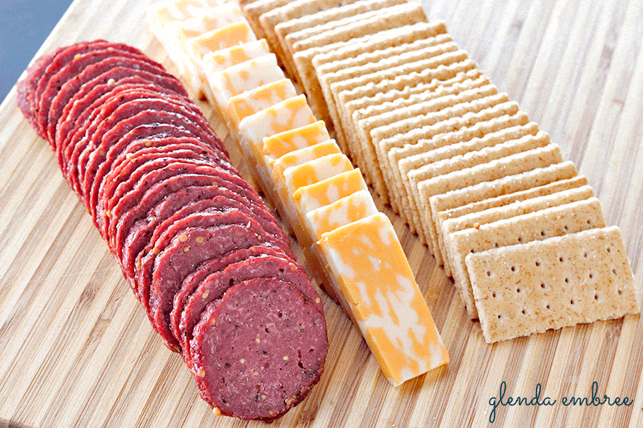 Homemade Beef Summer Sausage on wooden board with marble jack cheese and whole grain crackers