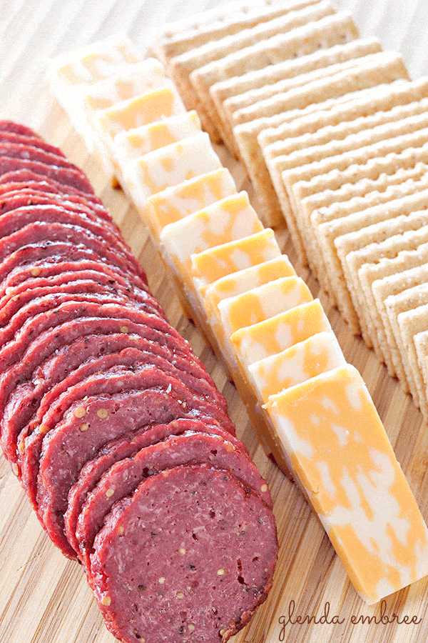 homemade beef summer sausage on wooden board with cheese and crackers