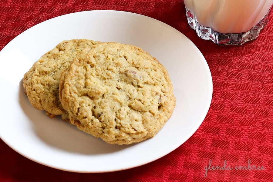 oatmeal cookies on a dessert plate with a glass of milk on the side