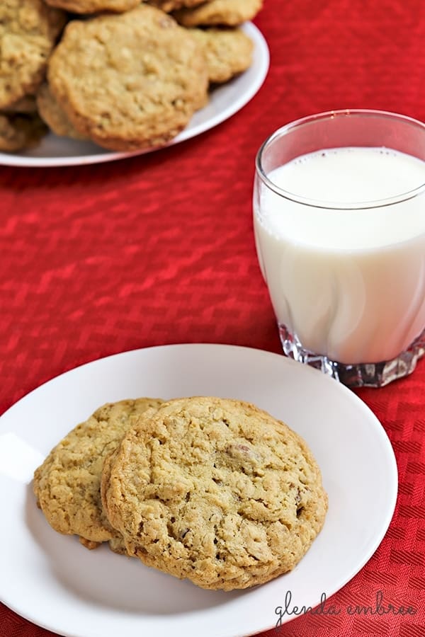 oatmeal cookies on a dessert plate with a glass of milk on the side