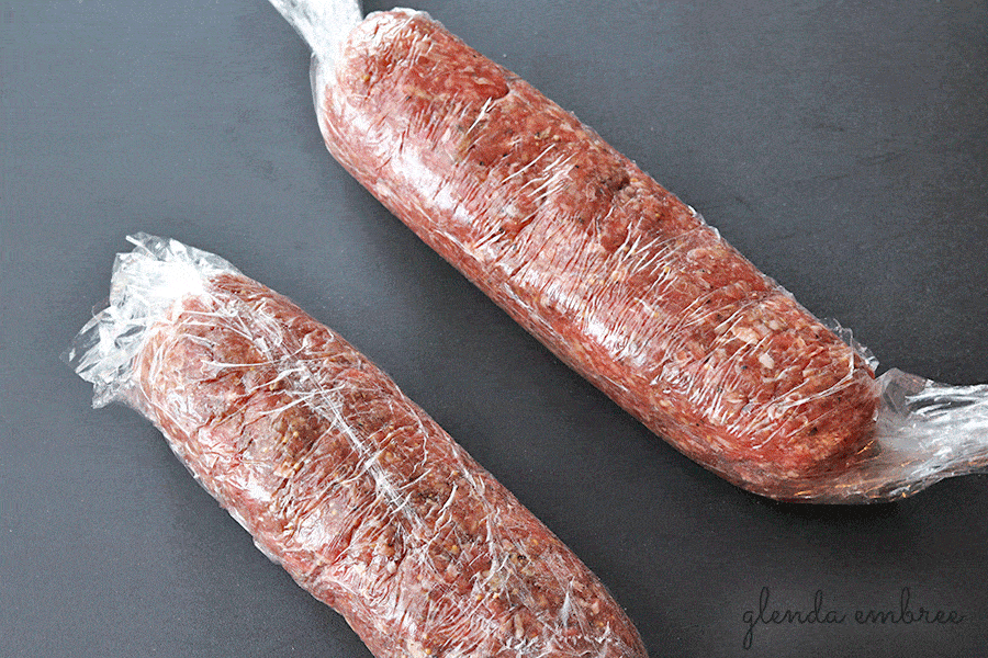 homemade beef summer sausage rolled into logs and sealed into plastic wrap for 24 hour refrigeration
