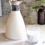 Cashew Coconut Milk in a glass bottle with a glass of Cashew Coconut Milk on the side. Fabulous dairy alternative and non-dairy blend.