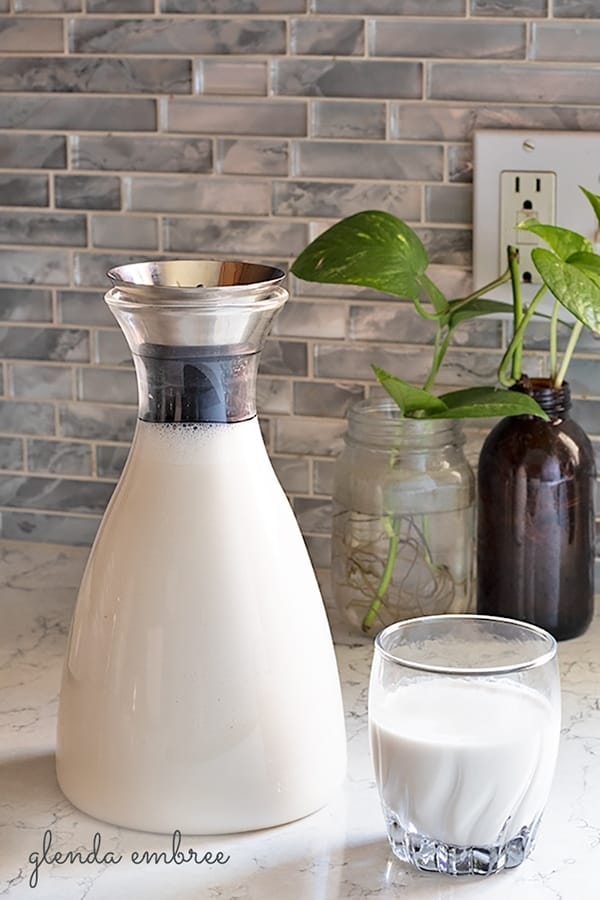 Cashew Coconut Milk in a glass bottle with a glass of Cashew Coconut Milk on the side.  Fabulous dairy alternative and non-dairy blend.