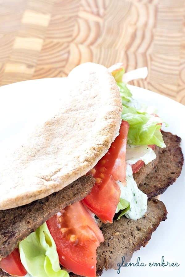 easy homemade gyro meat served on pita flat bread with lettuce, tomato slices, onion slivers and tzatziki sauce
