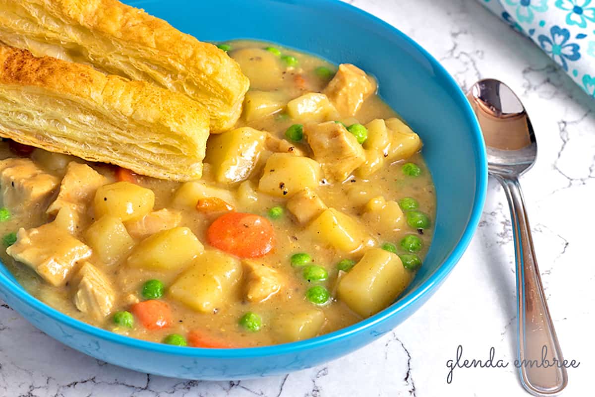 chicken pot pie soup in a bowl with puff pastry sticks