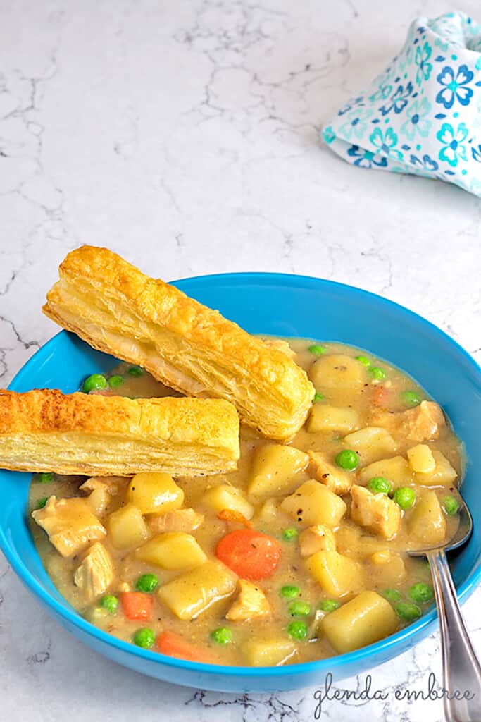 chicken pot pie soup in a bowl with puff pastry sticks