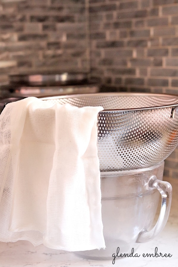 Straining Cashew Coconut Milk through a cheesecloth lined colander.