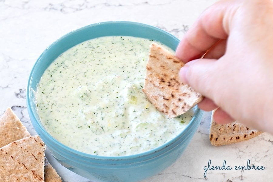 homemade tzatziki sauce in a blue bowl with pita chips