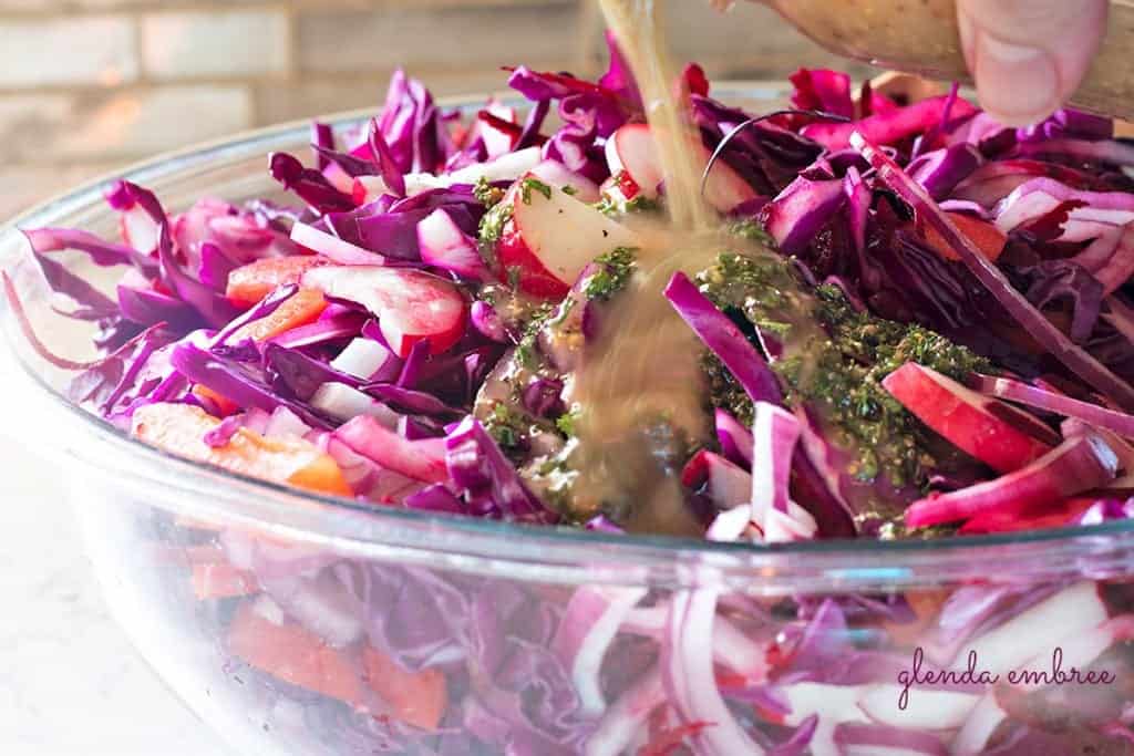 Pouring dressing over Ruby Coleslaw