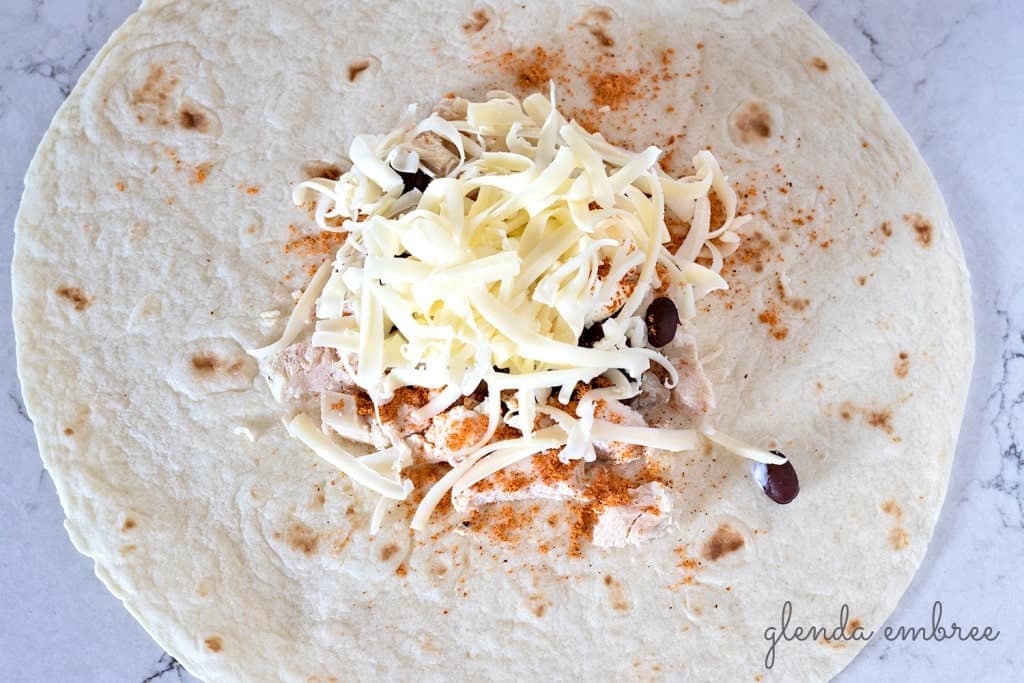 How to Assemble a Crunch Wrap: Add grated cheese.