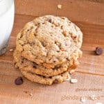 gluten free oatmeal chocolate chip cookies stacked next to a glass of milk