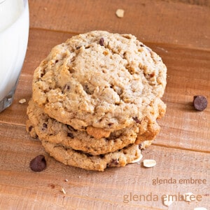 gluten free oatmeal chocolate chip cookies stacked next to a glass of milk