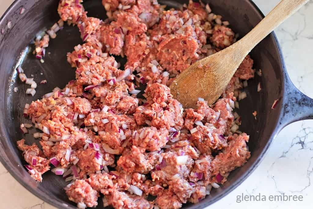 ground beef and onions in a cast iron skillet