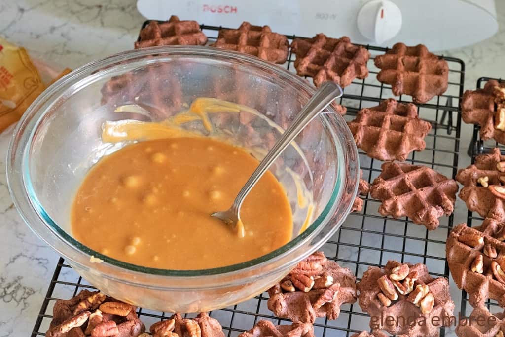 melted caramel on a cooling rack next to chocolate waffle cookies