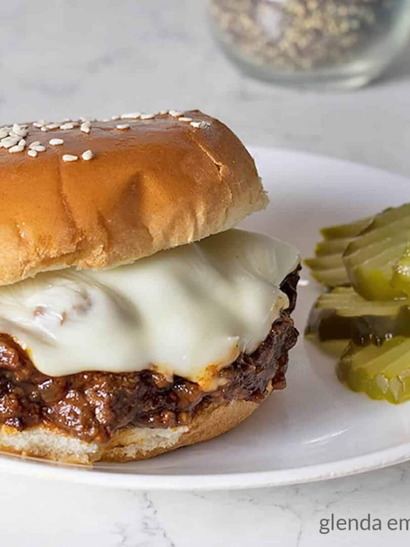 sloppy joes on a plate with dill pickle slices