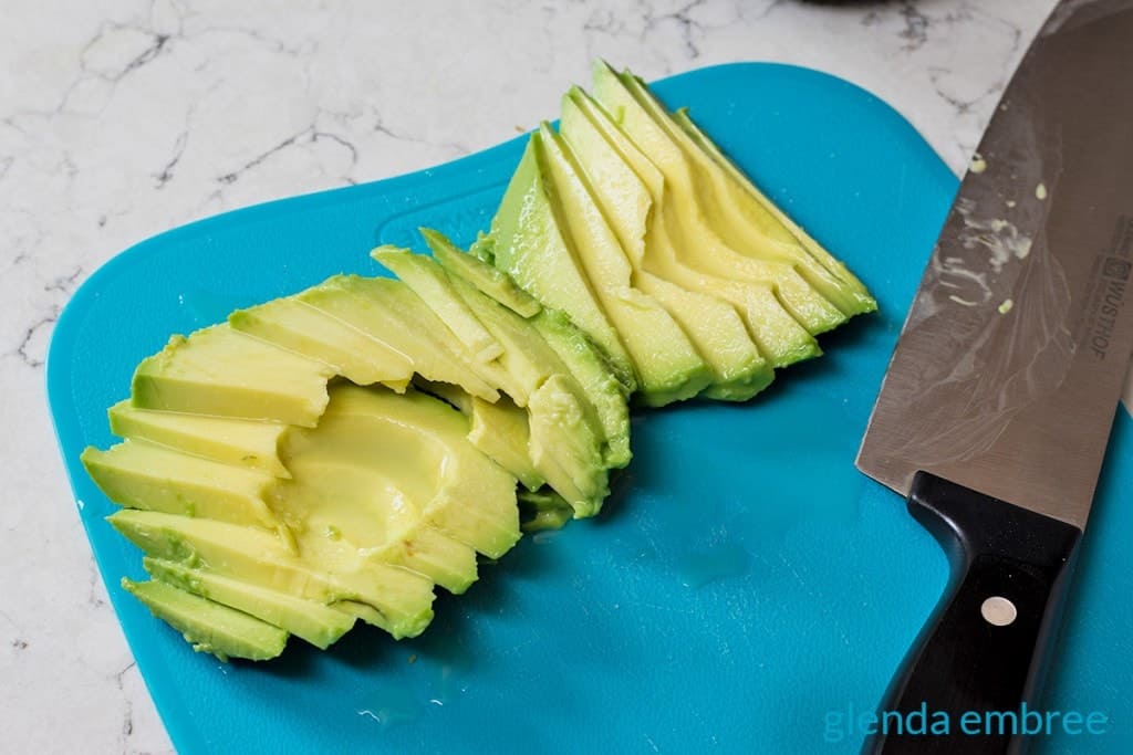 sliced avocado on a blue cutting board