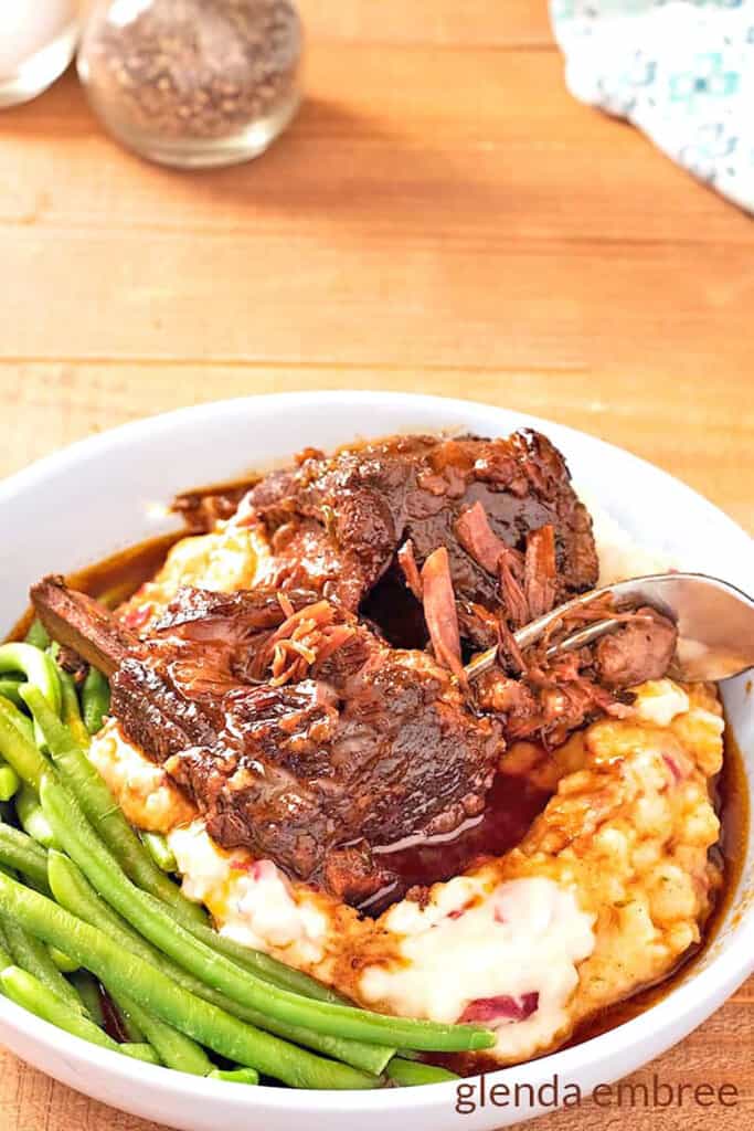 Braised Beef Short Ribs over Mashed Potatoes with fresh green beans.