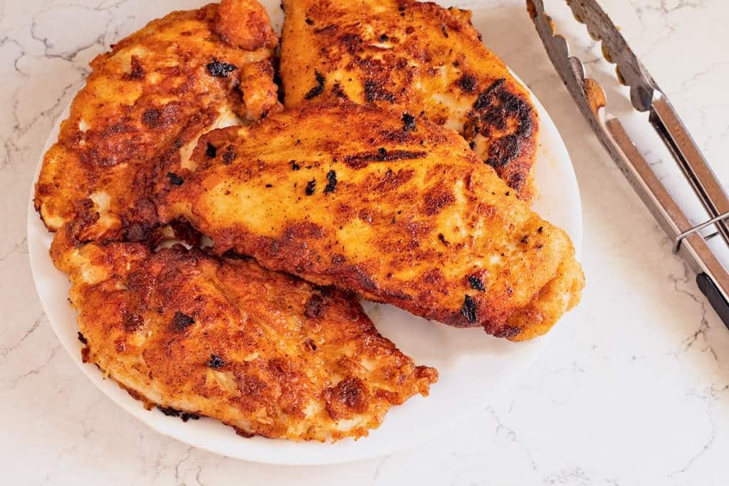 Cajun Fried Chicken Breasts on a white plate.