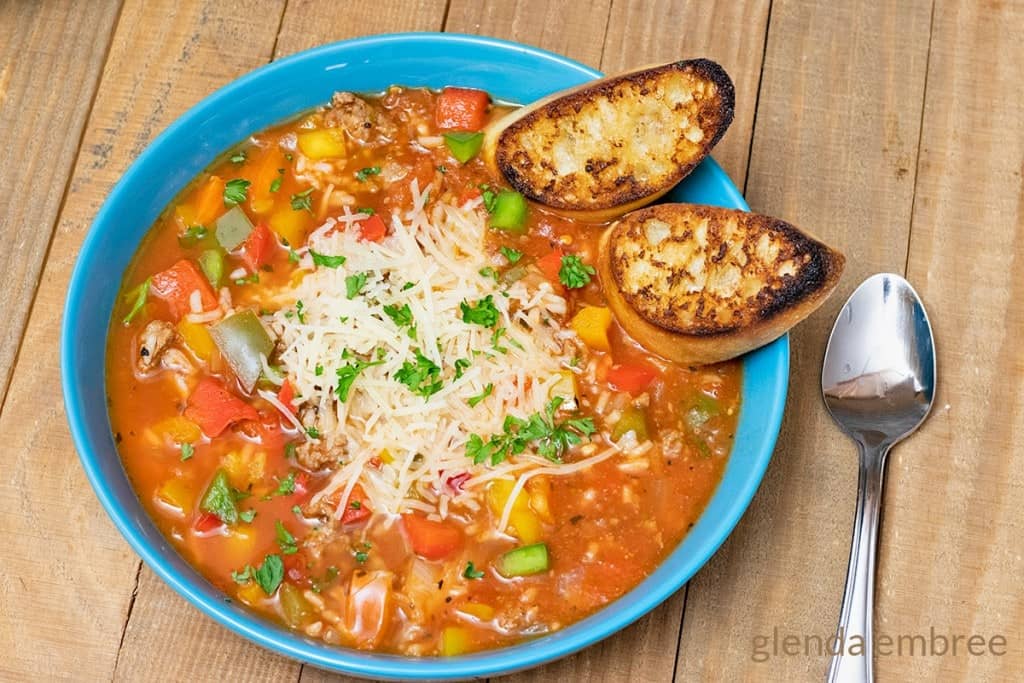 Stuffed Pepper Soup in a blue bowl with toasted crostini