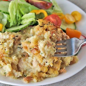 thanksgiving casserole on a plate with a tossed green salad