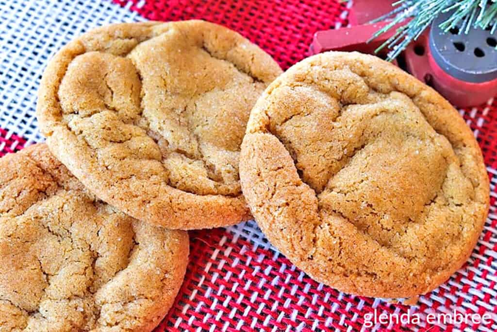 Soft Ginger Cookies on red and white checked cloth, next to a train Christmas ornament