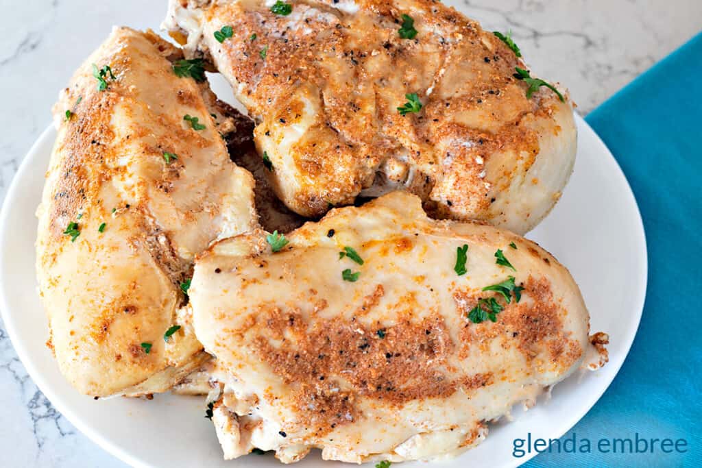 delicious chicken breast in crock pot, cooked and unsliced on a platter